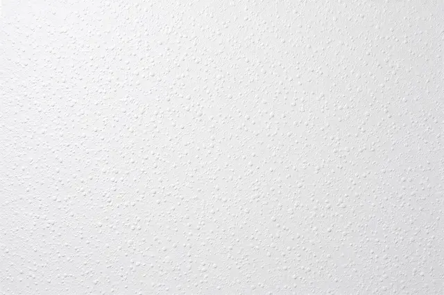 Full frame close-up of a white orange peel drywall finish with fine rounded raised bumps