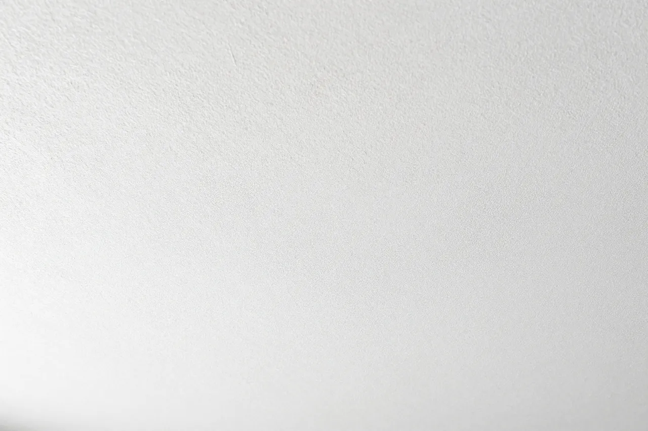Full frame close-up of a subtle textured white knockdown stucco ceiling surface