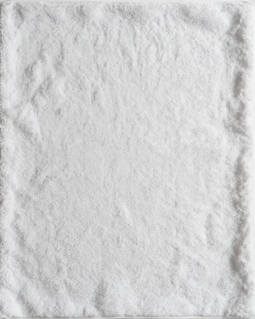Full frame close-up of soft dense white terry cloth fabric with subtle loop texture
