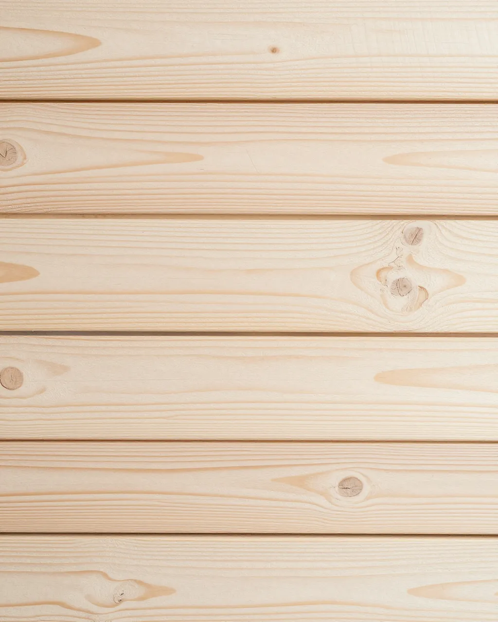 Full frame close-up of horizontal whitewashed pine planks with visible grain and natural knots