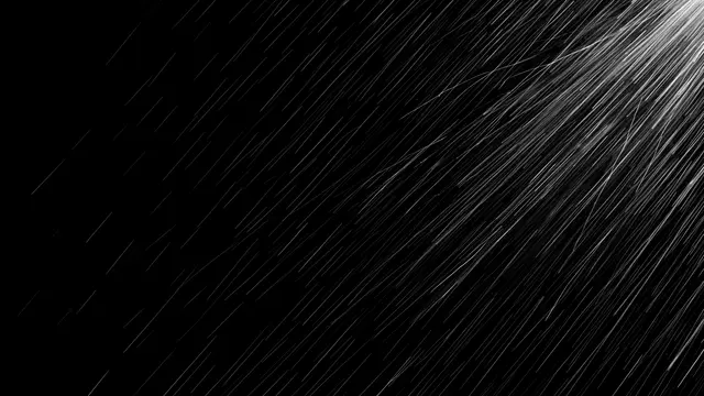 Slanting wind-driven rain streaks fall diagonally from the right across a solid pure black background