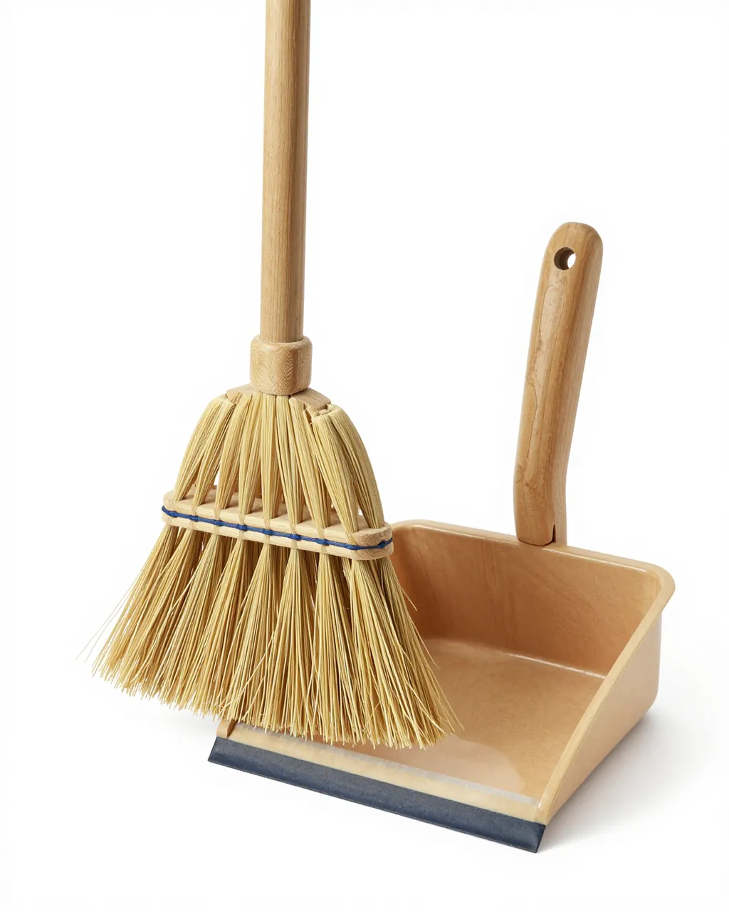 Wooden broom with natural bristles sits next to a matching wood dustpan on a pure white studio background