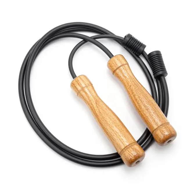 A jump rope with light wooden handles coiled loosely on a plain white background