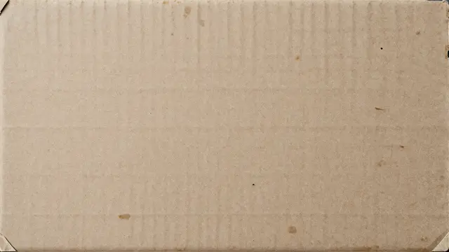 Full frame close-up of aged scuffed cardboard with faint stains and frayed corner edges under even light