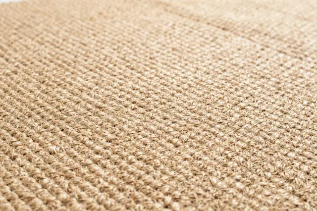 Close-up view of the textured woven surface of a natural jute rug