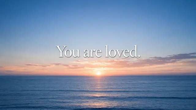 Calm ocean sunrise with soft white serif text reading "You are loved." centered in the sky.