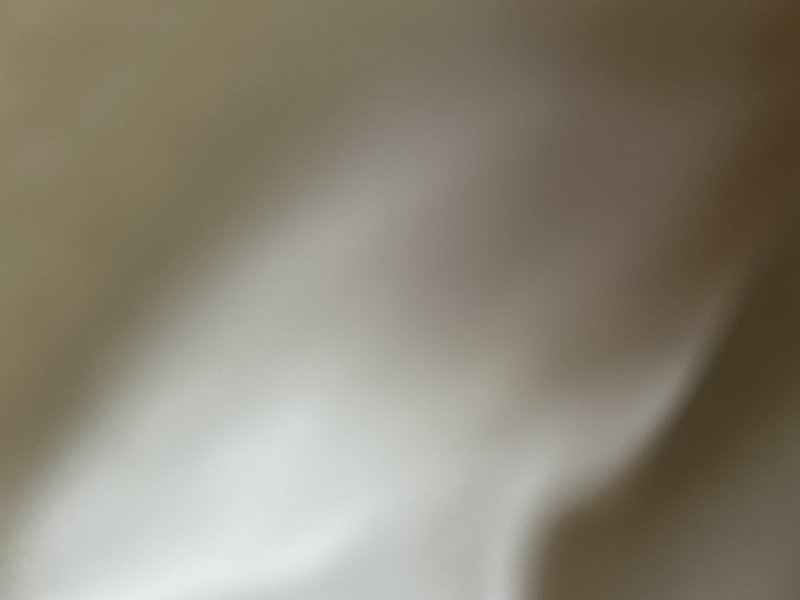 Soft blurred abstract gradient background of warm neutral beige, cream, and light brown tones with diffused flowing light.