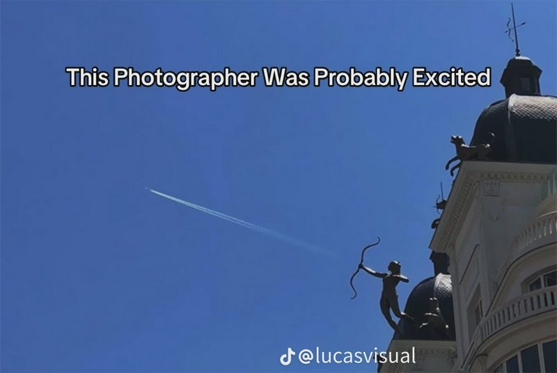 Funny forced perspective meme: archer statue aligns with jet contrail, joke text over bright clea...