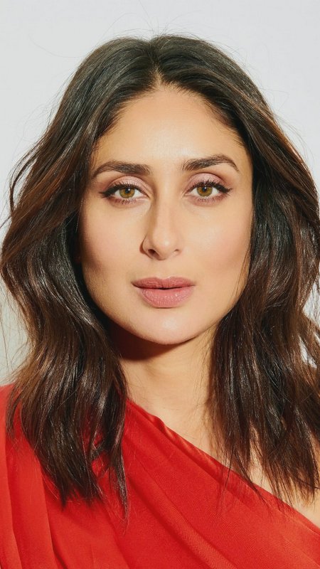 Close-up studio portrait of Bollywood actress Kareena Kapoor Khan in a bright red saree, with wav...