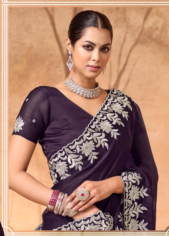 Studio portrait of an Indian model wearing a deep purple embroidered saree and silver polki occas...
