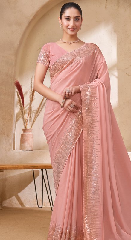 Model wearing a dusty blush pink sequin-embellished designer party wear saree in a warm neutral s...