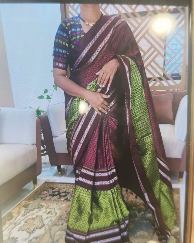 Unrecognizable model wearing a rich woven maroon and green traditional silk saree with matching p...