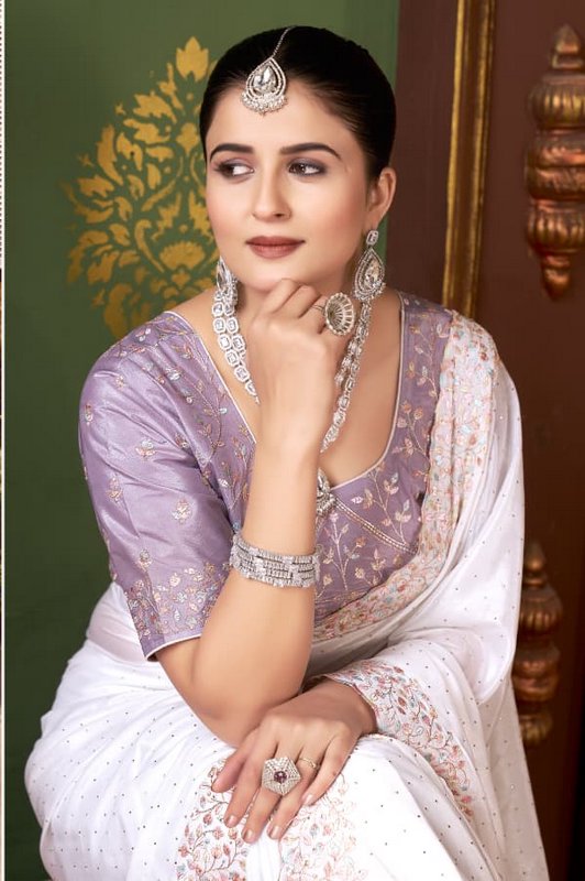 Portrait of elegant South Asian woman in embroidered saree wearing sparkling traditional diamond ...