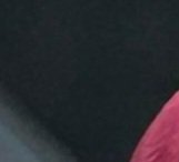Heavily blurred dark textured background with partial soft pink fabric detail visible in the bott...