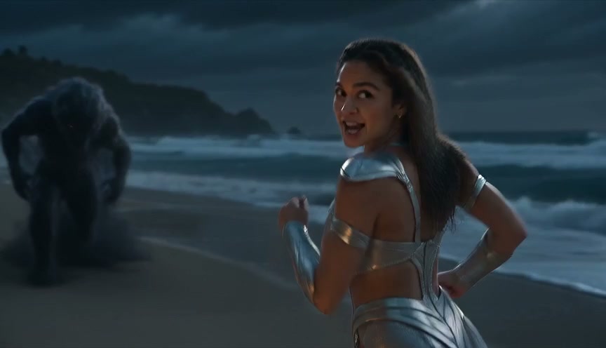 Woman in silver warrior armor glances back as a shadow sand monster pursues her on a dark stormy ...