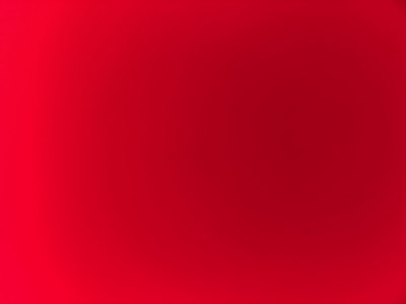 A smooth red gradient background with a rich crimson tone