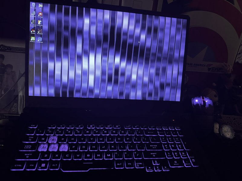 Gaming laptop with vertical purple screen glitch and purple RGB backlit keyboard in a dark gaming...