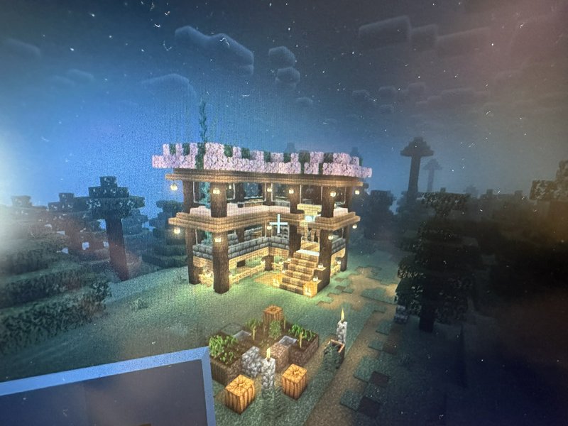 Shadered screenshot of a cozy lit two-story Minecraft cabin with cherry blossom roof at night