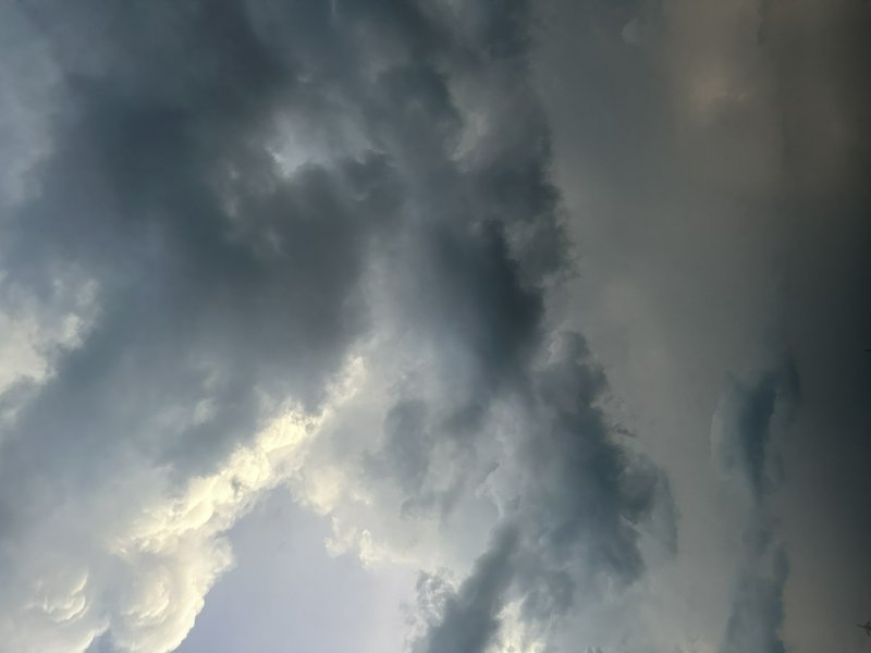 Low angle view of dramatic roiling storm clouds with sunlight peeking through gaps in a pre-thund...