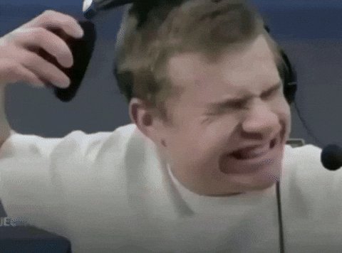 Frustrated streamer grimaces while yanking one side of his gaming headset off his head