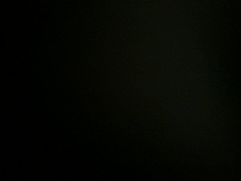 Nearly solid grainy dark background, primarily deep black with faint muted dark green undertones ...