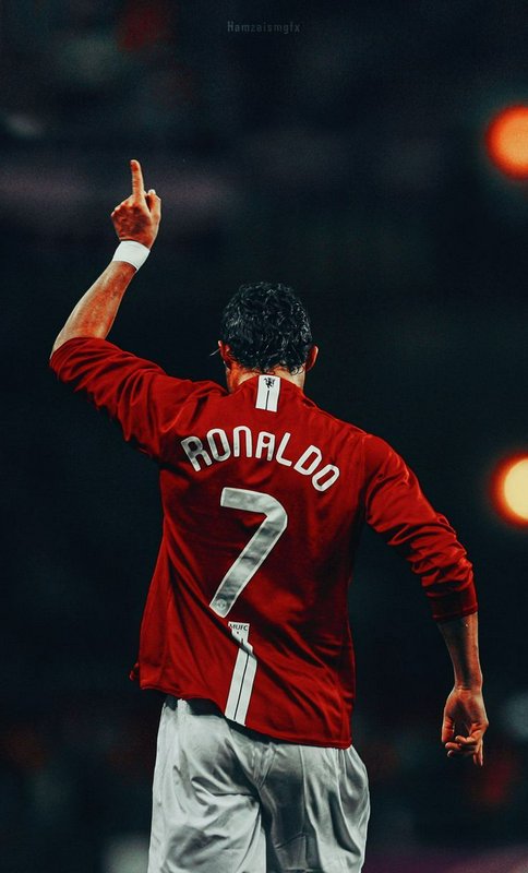 Cristiano Ronaldo in a Manchester United number 7 jersey raises a finger in celebration viewed fr...