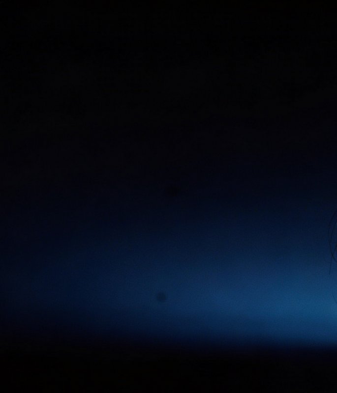 Smooth gradient background fading from inky black edges to soft hazy deep blue center, faint stra...