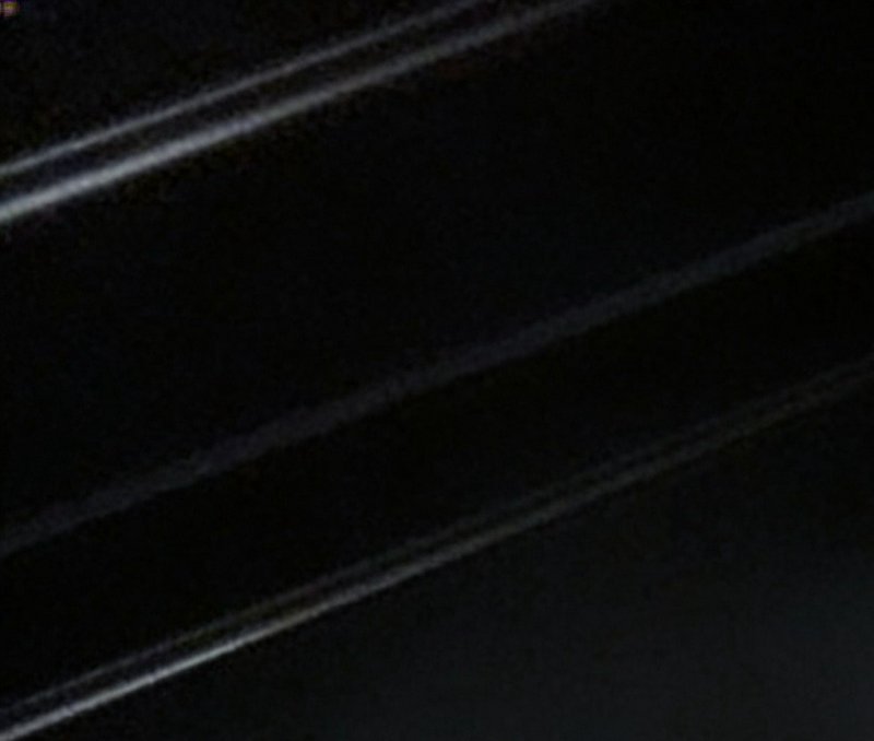 Low-light close-up of dark polished staircase steps with thin pale diagonal edge trim lines in a ...