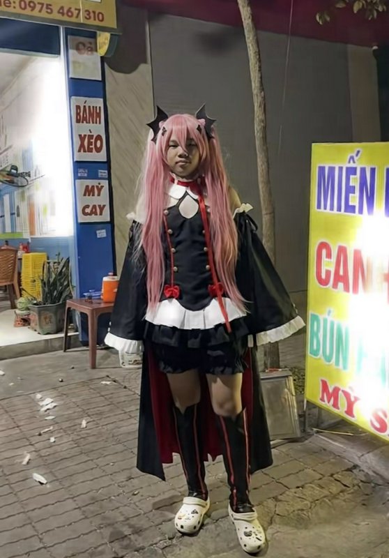 Cosplayer in Krul Tepes anime costume wears decorated Crocs while standing on a nighttime Vietnam...