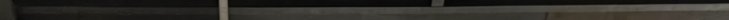 Extremely narrow pixelated horizontal strip with muted dark grey, black, and faint light vertical...