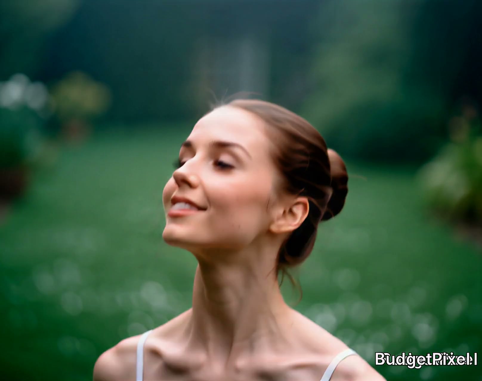 Woman outdoors with eyes closed and a serene smile, in a green garden with soft bokeh background.