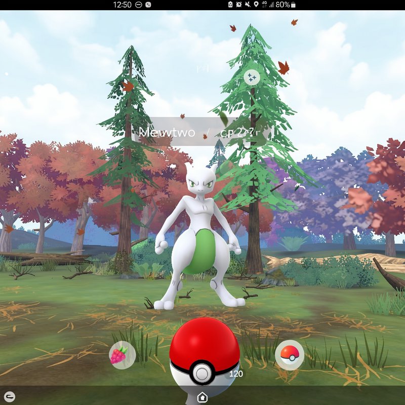 Shiny Mewtwo stands in an autumn forest during a Pokemon GO wild encounter, with a Pokeball ready...