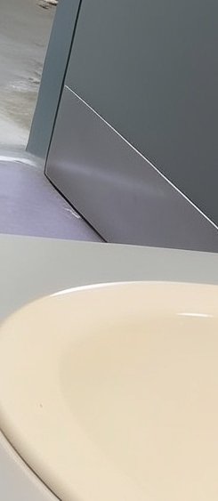 Partial close-up of modern yacht interior, showing cream upholstered seating, grey geometric wall...
