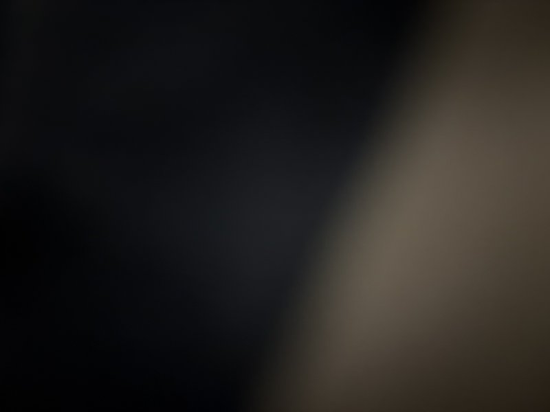 Soft blurred abstract gradient background, deep inky dark navy left transitions smoothly to warm ...