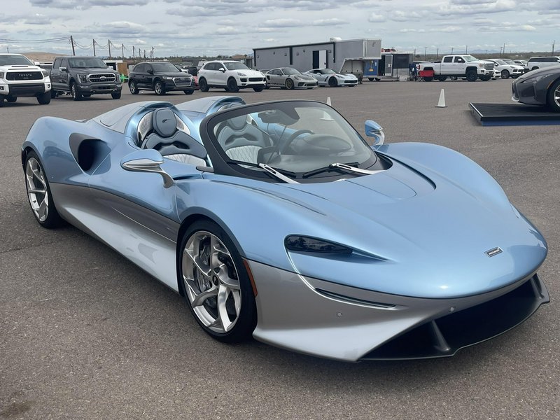 Glossy two-tone light blue and silver McLaren Elva open-top hypercar parked at an outdoor exotic ...