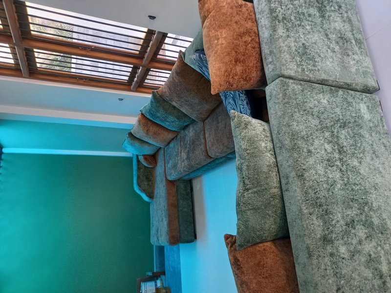 Plush multi-tone modular velvet sectional sofa next to teal accent wall under a wooden framed sky...