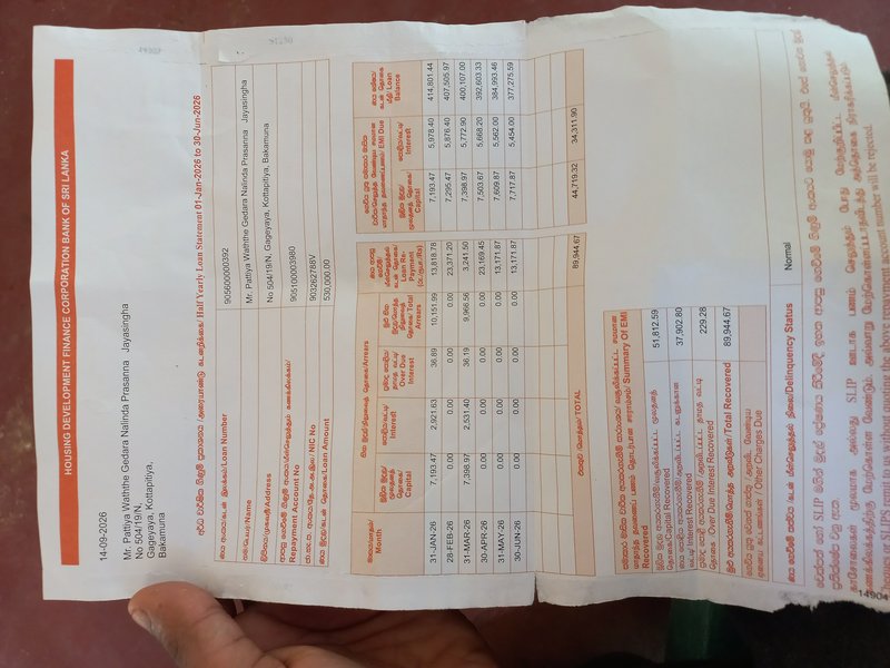 Hand holding a printed half-yearly housing loan statement from HDFC Bank of Sri Lanka