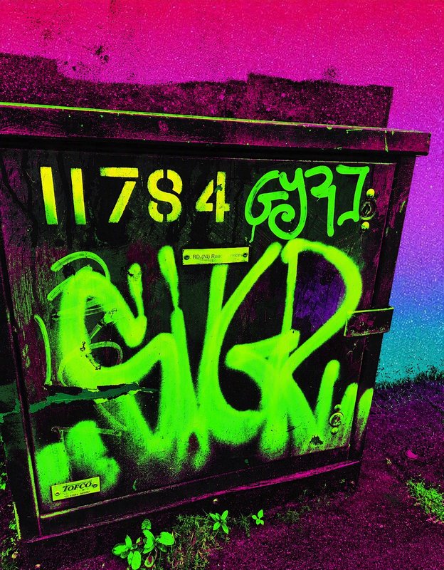 Psychedelic filtered view of neon green spray paint graffiti on a public street utility box