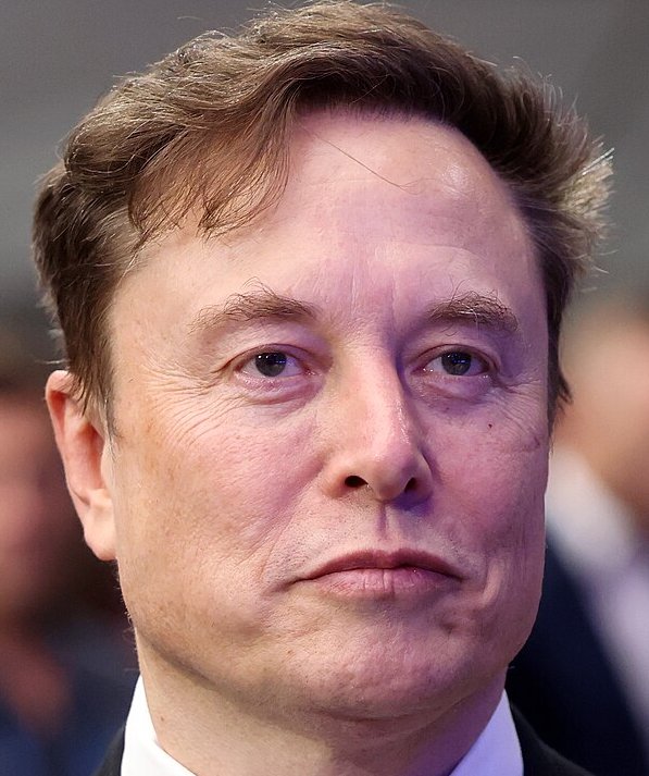 Close-up headshot of Elon Musk with a serious neutral expression, captured at a formal public event.
