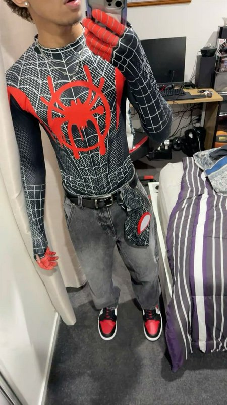 Young person wearing a Miles Morales Spider-Man top takes a mirror selfie in a bedroom