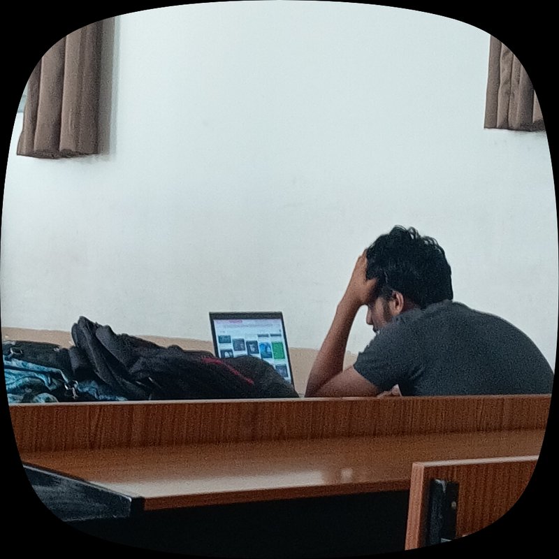 Candid shot of a stressed male student resting his head on his hand while viewing a laptop at a l...