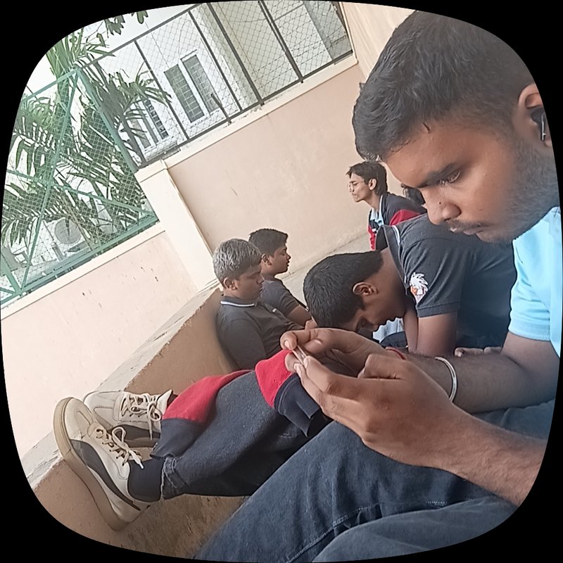 Group of young male friends sitting casually on a residential balcony, foreground man focused on ...