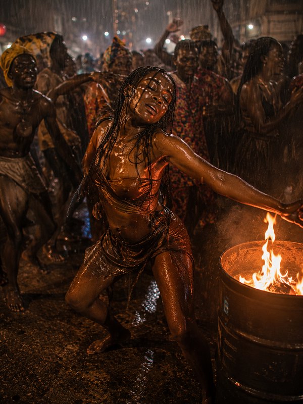 Woman dancing in the rain at a night festival with a fire barrel, drenched and joyful.
