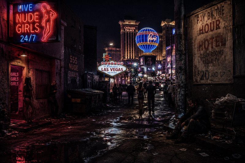 Neon-lit Las Vegas street at night with the famous Welcome to Las Vegas sign and sultry neon ads.
