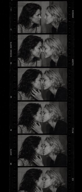 Black-and-white film strip showing two women kissing in multiple frames