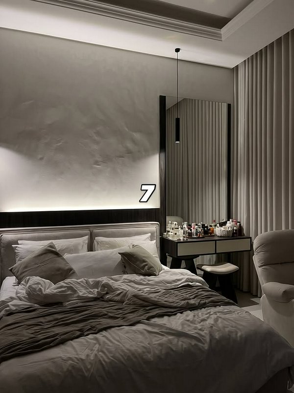 Moody quiet luxury bedroom with unmade plush linen bed, textured plaster accent wall, vanity desk...