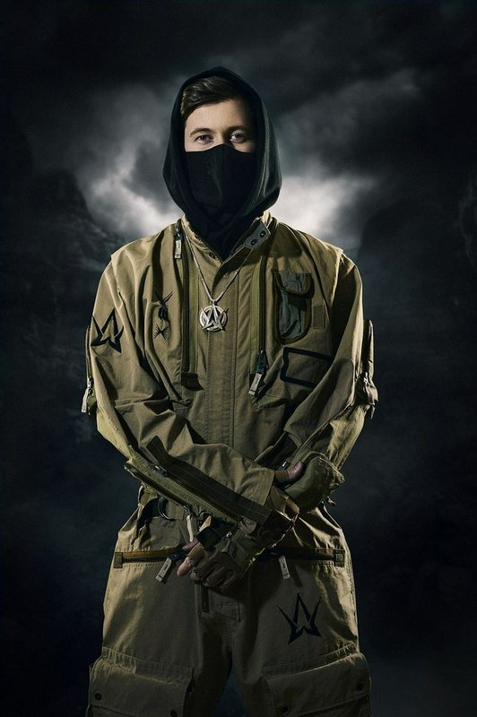 Cinematic portrait of masked EDM artist Alan Walker in tactical tan jumpsuit against dark stormy ...