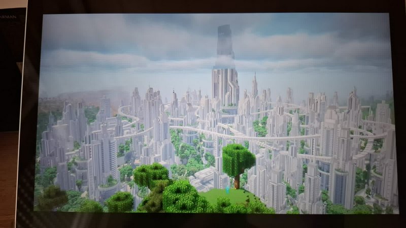 Elaborate custom futuristic skyscraper city build viewed from a grassy hill in Minecraft