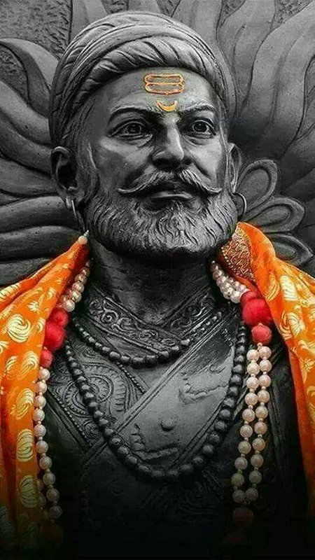 Close-up portrait of an ornate Chhatrapati Shivaji Maharaj statue with bright orange ceremonial s...