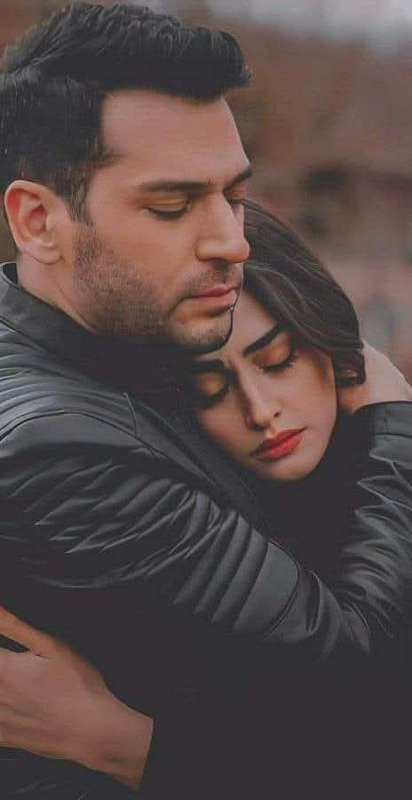 Couple in black leather jackets share a tender closed-eye embrace